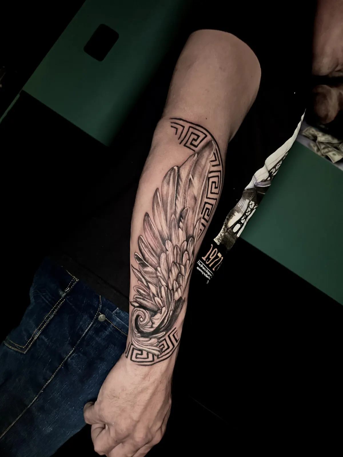 Tatuagem de asas de anjo em blackwork no antebraço, feita no estúdio Caliaro Art em Cuiabá