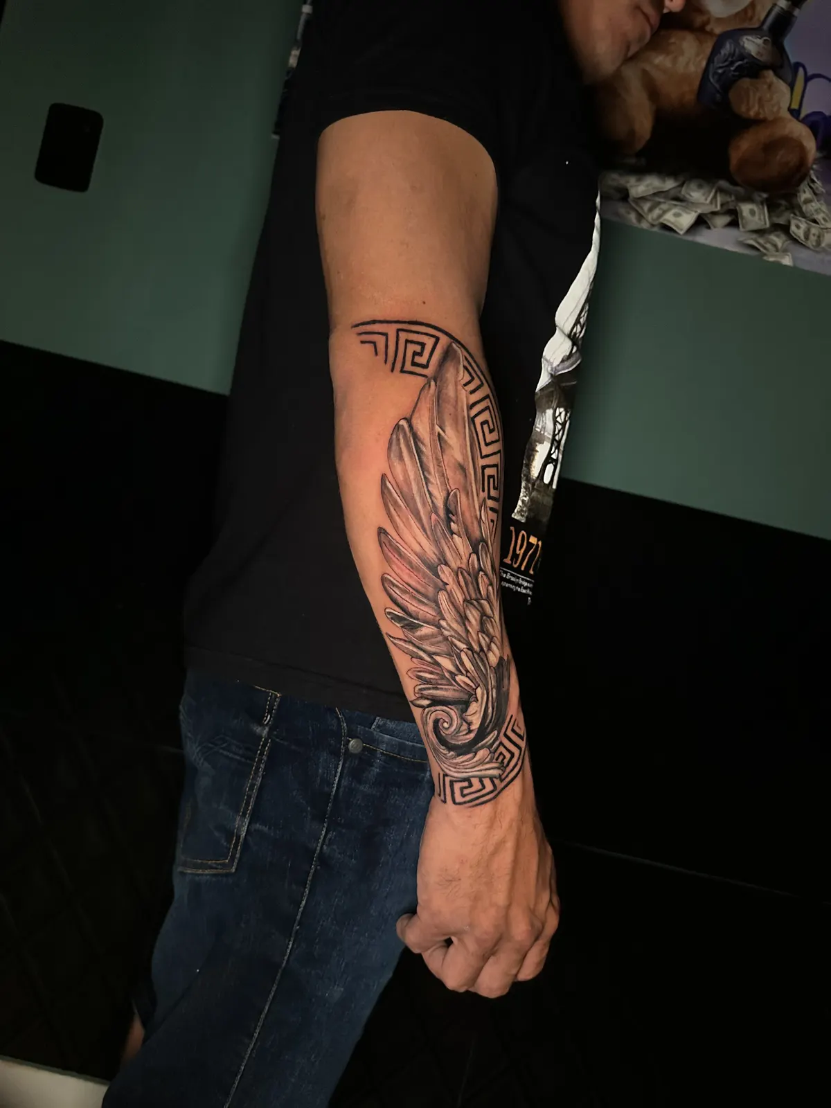 Tatuagem de anjo em blackwork no antebraço, outro ângulo, tema religioso