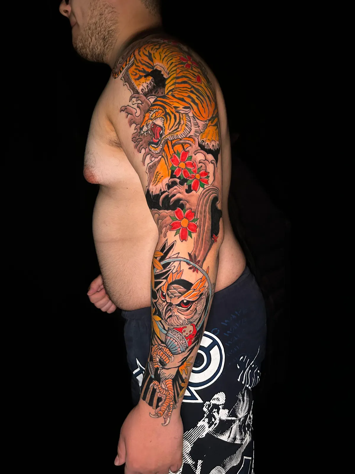 Tatuagem de capacete espartano em preto e cinza no braço