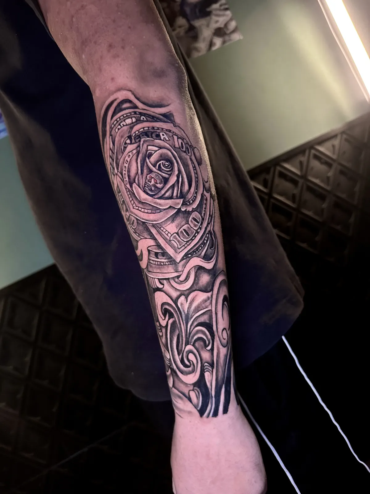 Tatuagem floral com linhas gestuais no antebraço