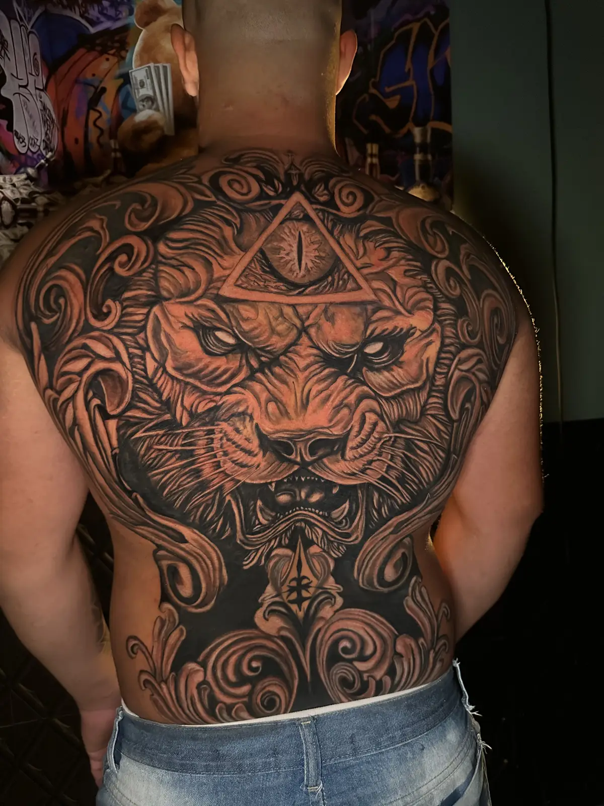 Tatuagem realista de leão fechando as costas, feita no estúdio Caliaro Art em Cuiabá