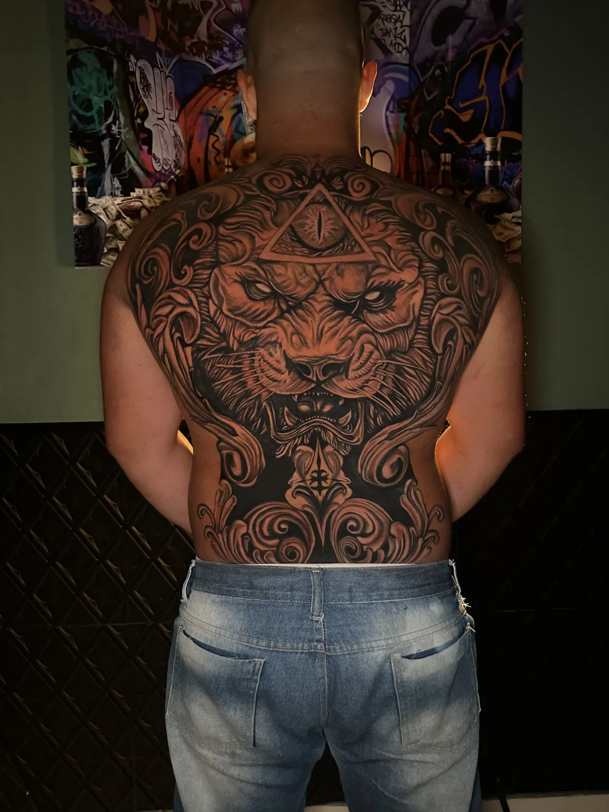 Tatuagem realista de leão nas costas ilustrando o guia da tatuagem do Caliaro Art em Cuiabá