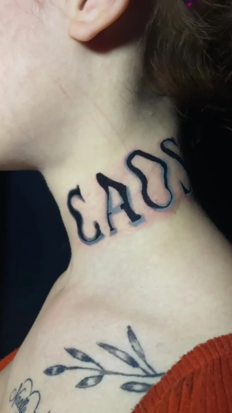 Tatuagem de lettering no pescoço com letra desenhada à mão