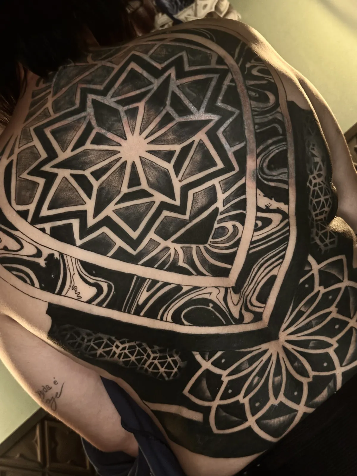Tatuagem geométrica com padrão de linhas nas costas