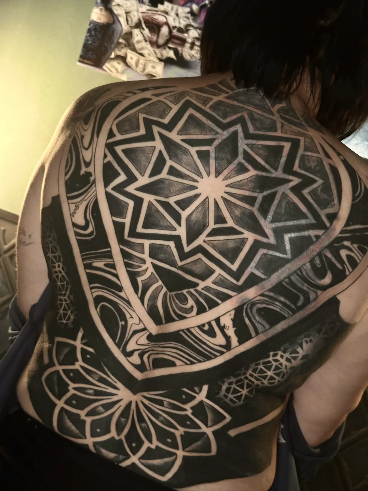 Tatuagem de mandala geométrica nas costas, outro ângulo do painel completo