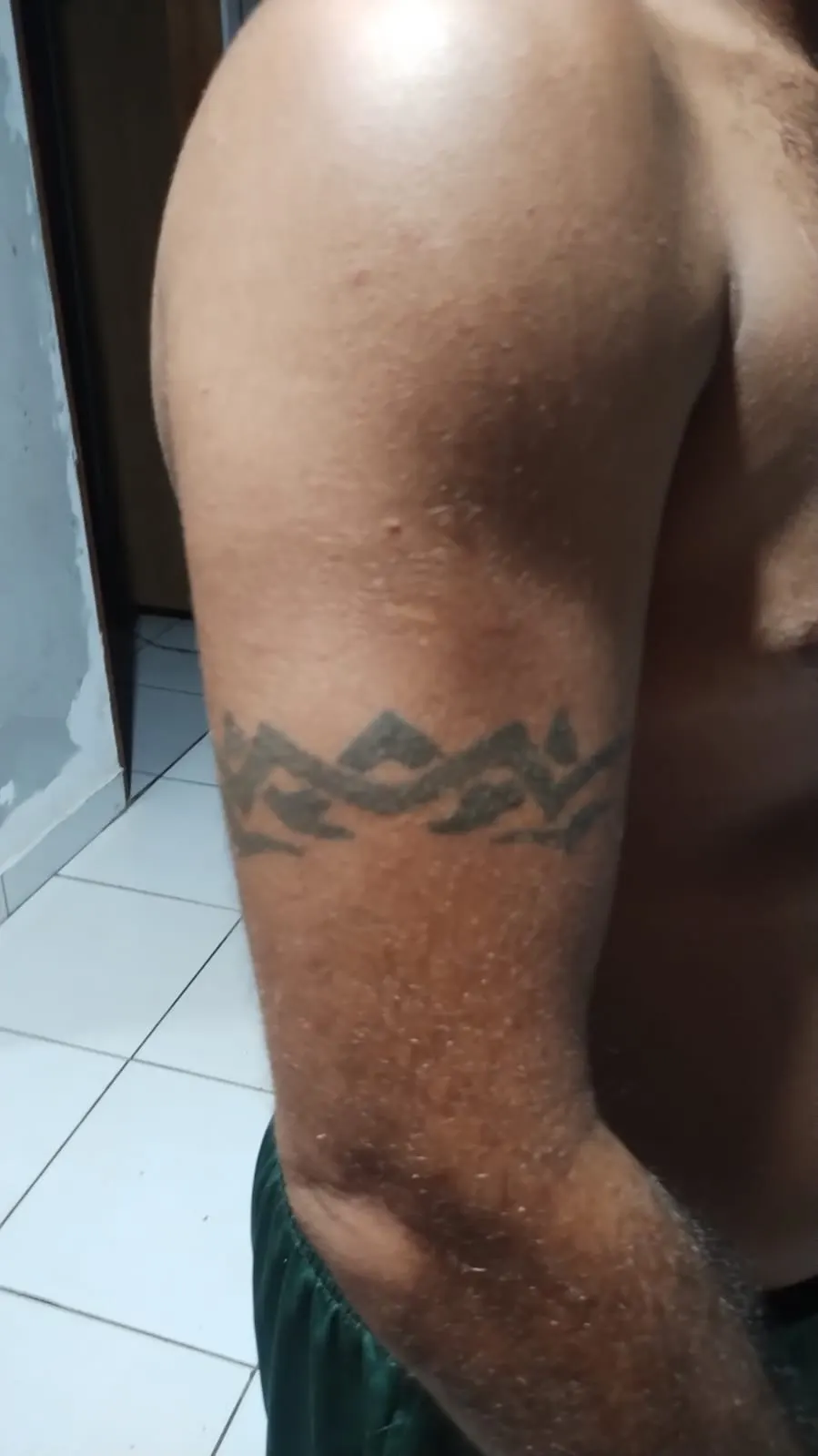 Tatuagem de cruz em blackwork na costela, símbolo de fé feito em Cuiabá