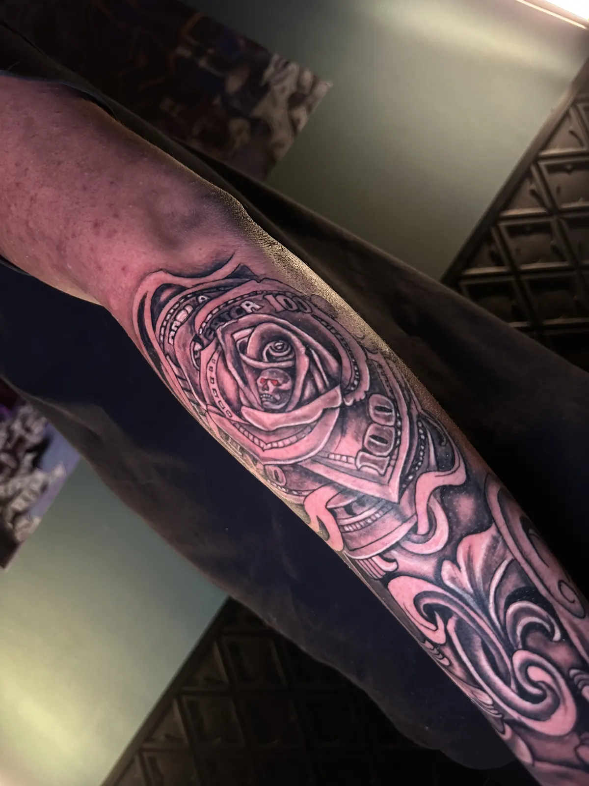 Tatuagem de rosa colorida no antebraço, efeito de pintura suave