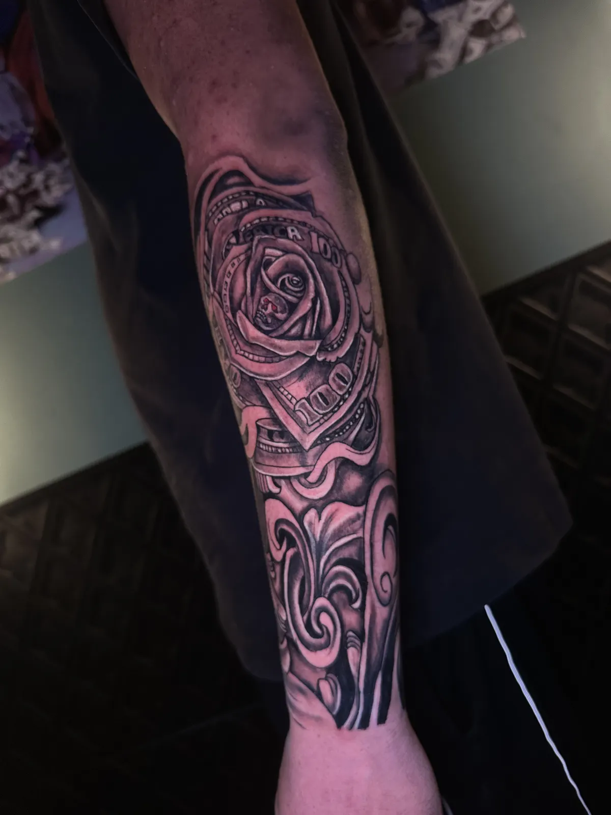 Tatuagem de rosa combinada com grafismos maori em blackwork no antebraço, feita em Cuiabá